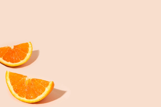 Deliciosos trozos de cítricos de naranja sobre un fondo naranja claro