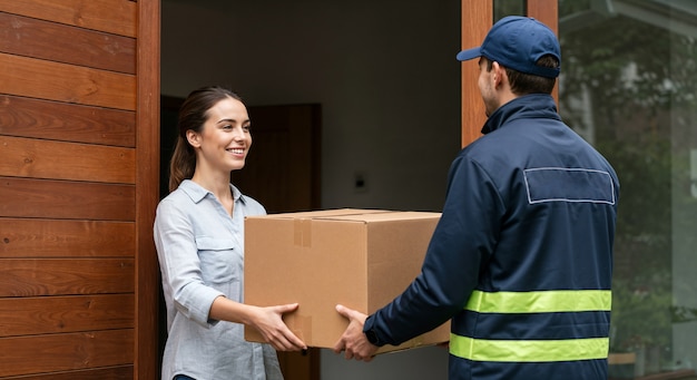 Delivery man handing package to woman at her doorstep