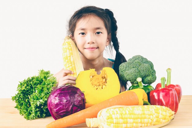 La demostración encantadora asiática de la muchacha disfruta de la expresión con las verduras coloridas frescas