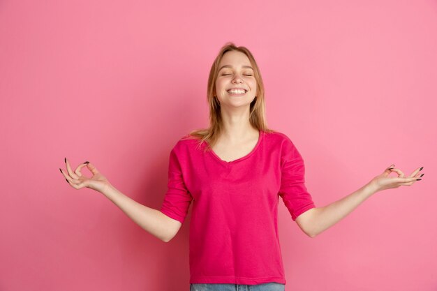 Demostración feliz y brillante. Retrato de mujer joven caucásica aislado en pared rosa, monocromo. Modelo de mujer hermosa. Concepto de emociones humanas, expresión facial, ventas, publicidad, moda.