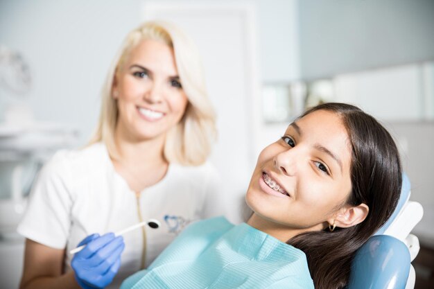 Dentista adulto medio con paciente en clínica dental