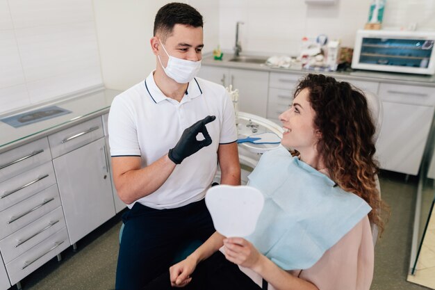 Dentista aprobando sonrisa paciente