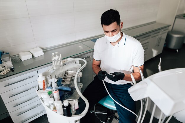 Dentista en consultorio preparando instrumentos quirúrgicos