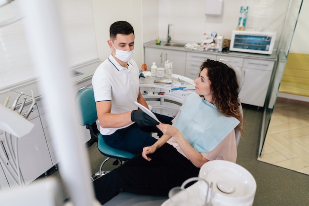 Foto gratuita dentista dando espejo al paciente en la oficina