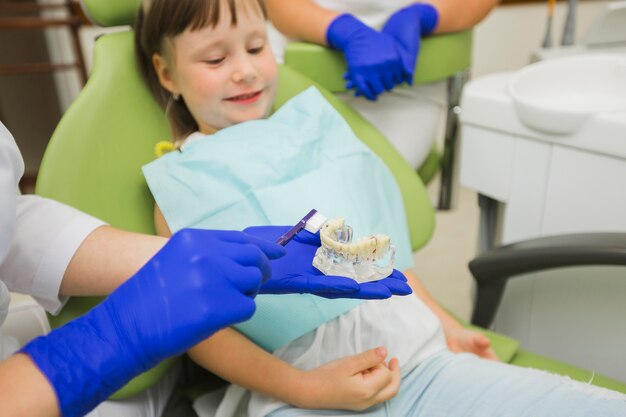 Dentista con dentaduras postizas con cepillo de dientes