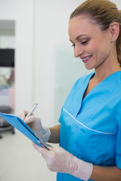 Dentista escribiendo un informe médico