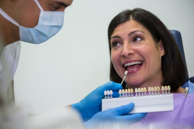 Dentista examina paciente femenino con tonos de dientes