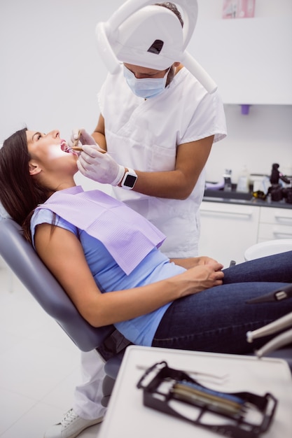 Foto gratuita dentista examinando los dientes del paciente femenino