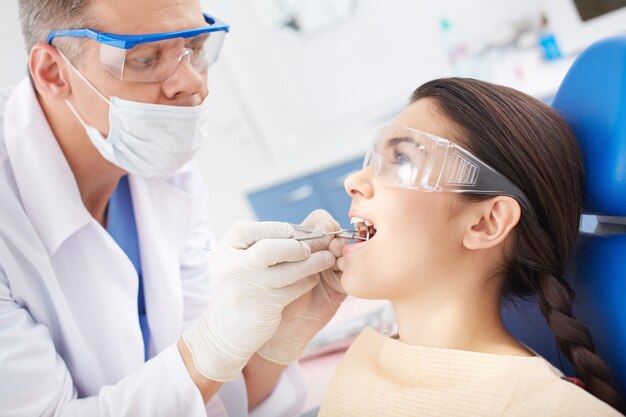 Dentista examinando los dientes de una paciente