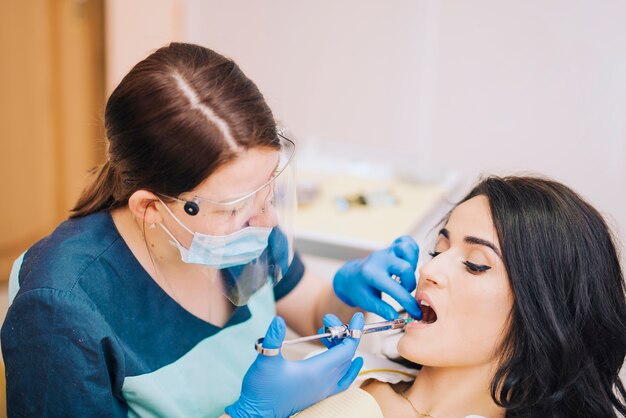 Dentista haciendo anestesia inyectable a paciente.