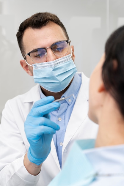 Foto gratuita dentista haciendo un chequeo al paciente