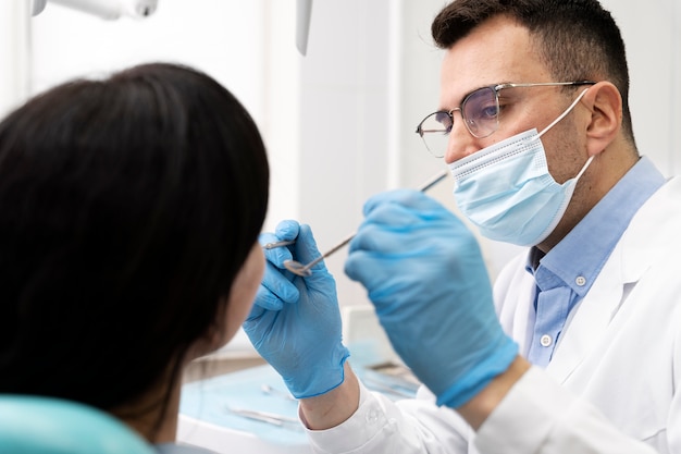 Foto gratuita dentista haciendo un chequeo al paciente