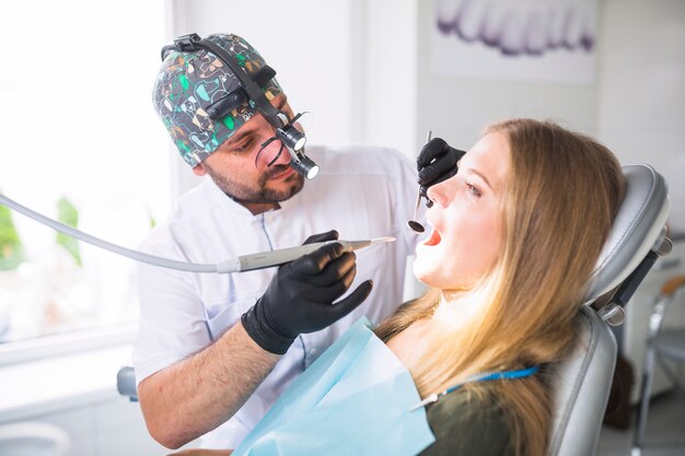 Dentista haciendo tratamiento dental en paciente femenino