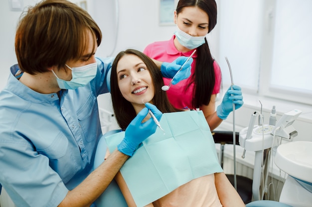 Dentista joven examinando a una paciente
