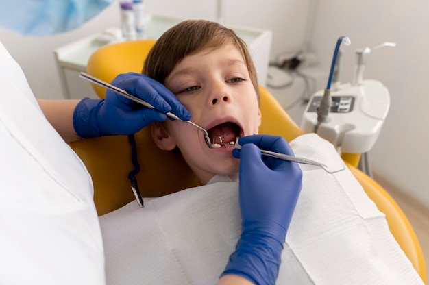 Dentista limpiando los dientes del niño