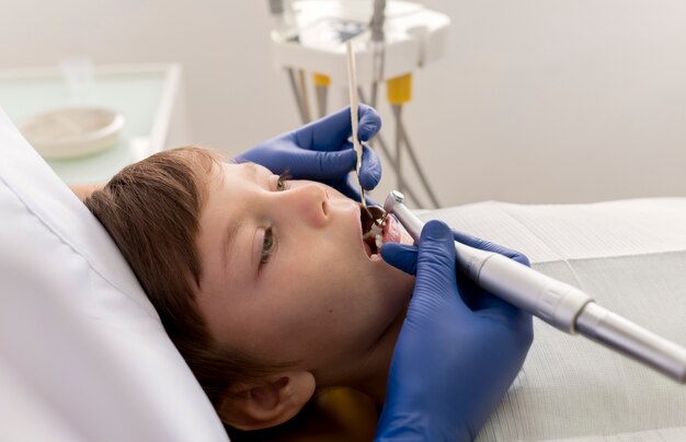 Dentista limpiando los dientes del niño