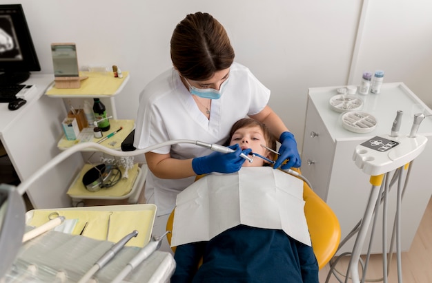 Dentista limpiando los dientes del niño