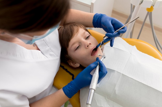 Dentista limpiando los dientes del niño