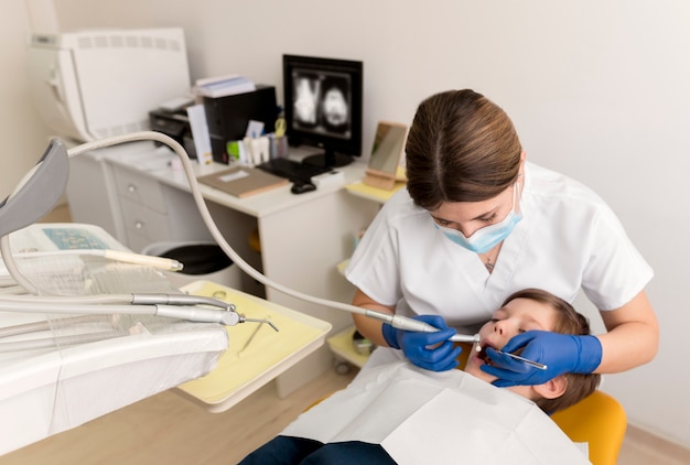 Dentista limpiando los dientes del niño