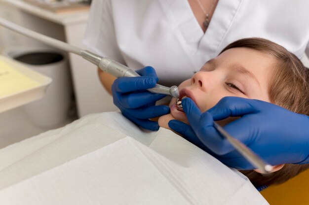 Dentista limpiando los dientes del niño