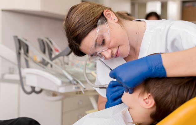 Dentista limpiando los dientes del niño