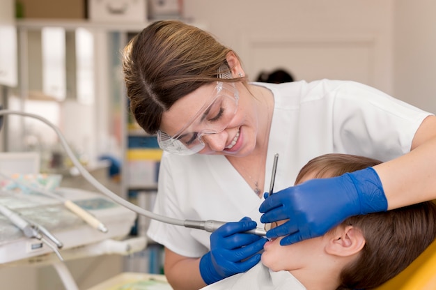 Dentista limpiando los dientes del niño