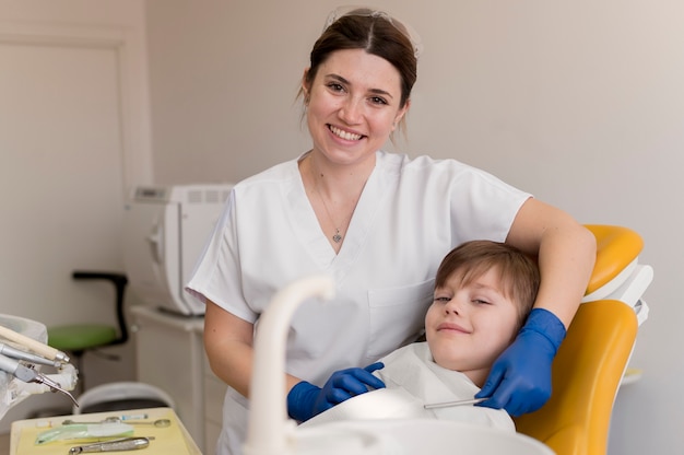 Foto gratuita dentista limpiando los dientes del niño