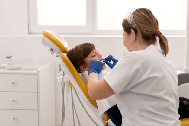 Foto gratuita dentista limpiando los dientes del niño