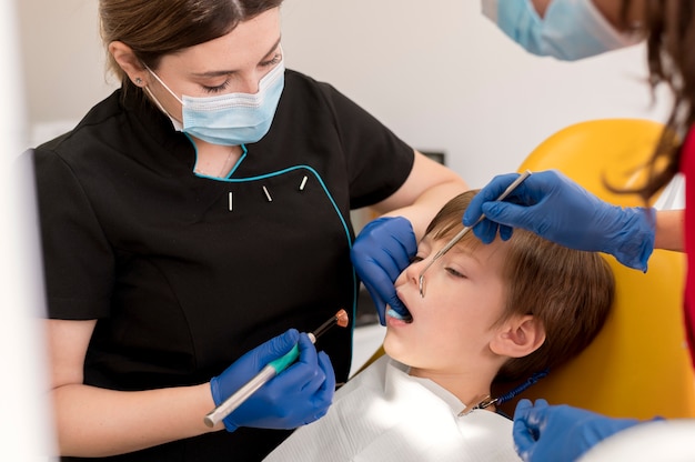 Dentista limpiando los dientes del niño