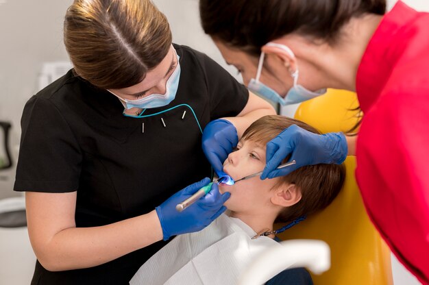 Dentista limpiando los dientes del niño