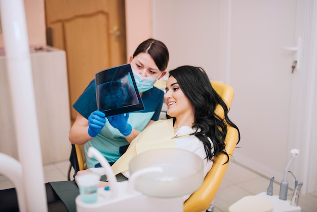 Dentista mostrando la radiografía de los dientes al paciente.