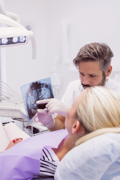 Dentista mostrando rayos x al paciente