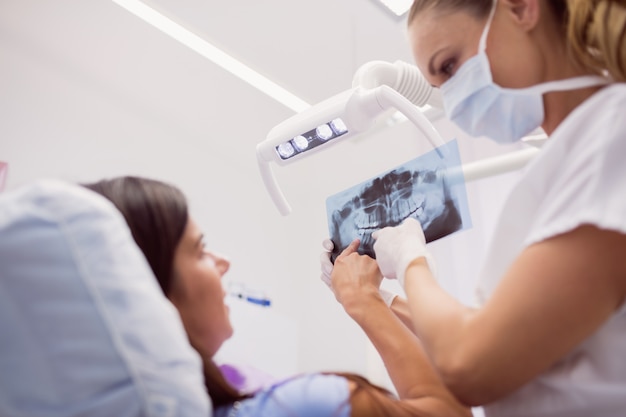 Foto gratuita dentista mostrando rayos x al paciente