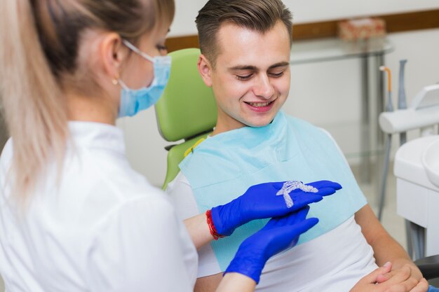 Dentista mostrando retenedores invisibles al paciente