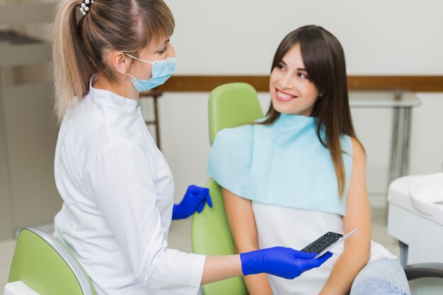 Dentista y paciente feliz mirándose