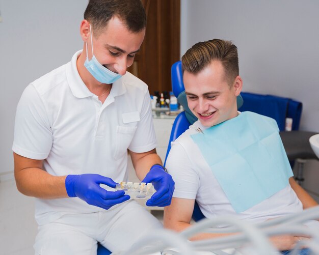 Dentista y paciente mirando los dientes