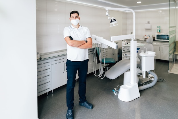 Dentista posando en el consultorio con mascarilla quirúrgica