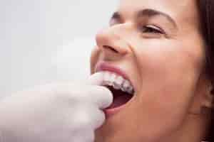 Foto gratuita dentista que ayuda a la paciente a usar aparatos ortopédicos