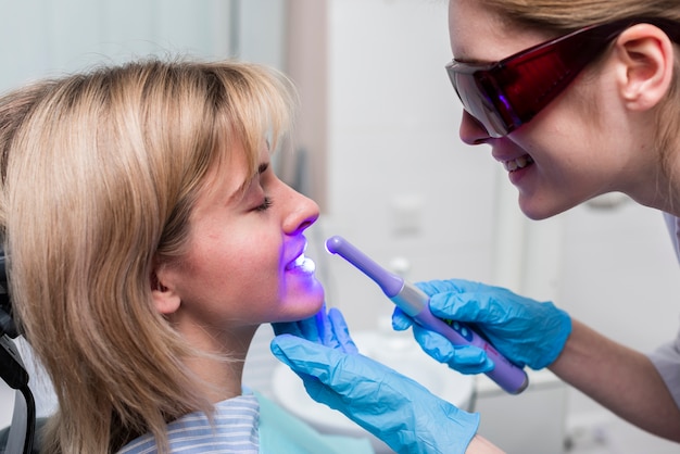 Dentista realizando blanqueamiento dental