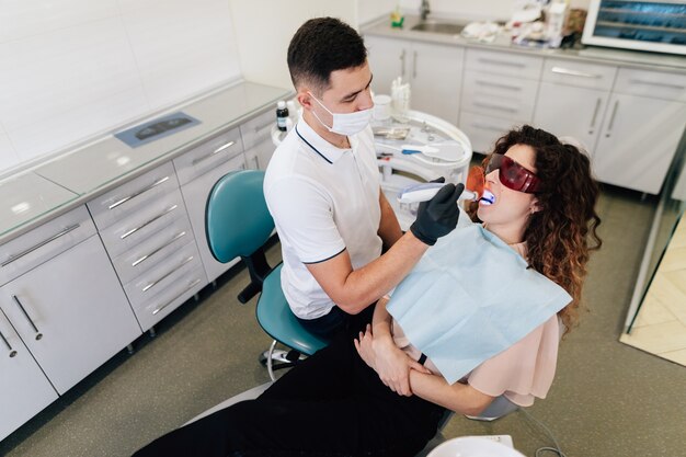 Dentista realizando blanqueamiento en paciente