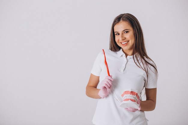 Dentista de sexo femenino con las herramientas de la odontología aisladas