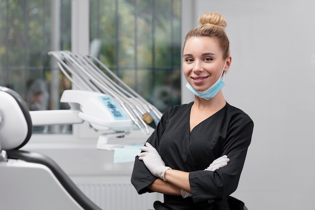 Foto gratuita dentista sonriente de tiro medio en la clínica