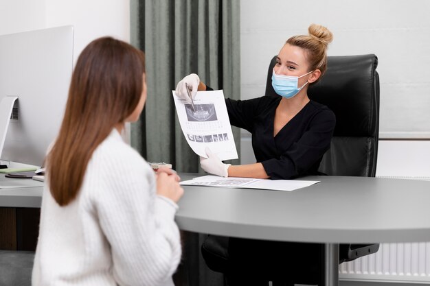 Dentista de tiro medio explicando la radiografía