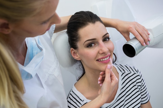 Dentista tomando una radiografía dental de pacientes femeninos