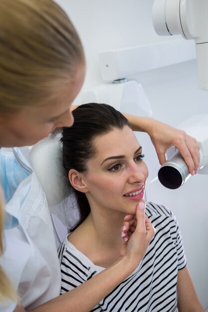 Dentista tomando una radiografía dental de pacientes femeninos