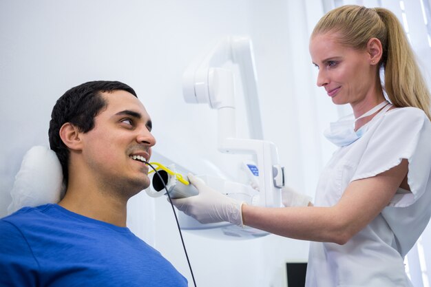 Dentista tomando una radiografía dental de pacientes masculinos