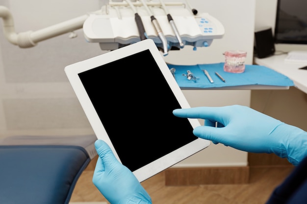 Foto gratuita dentista trabajando en tableta en clínica