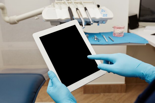 Dentista trabajando en tableta en clínica
