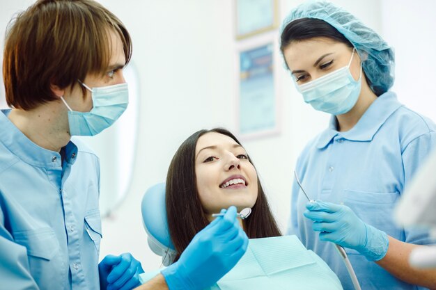 Dentistas con mascarillas en un examen dental