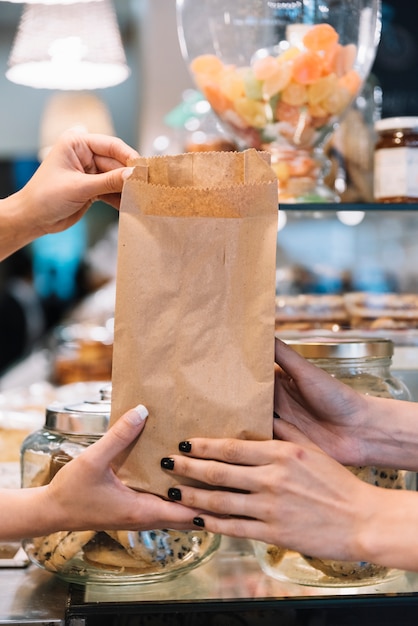 Dependienta dando bolsa de croisants